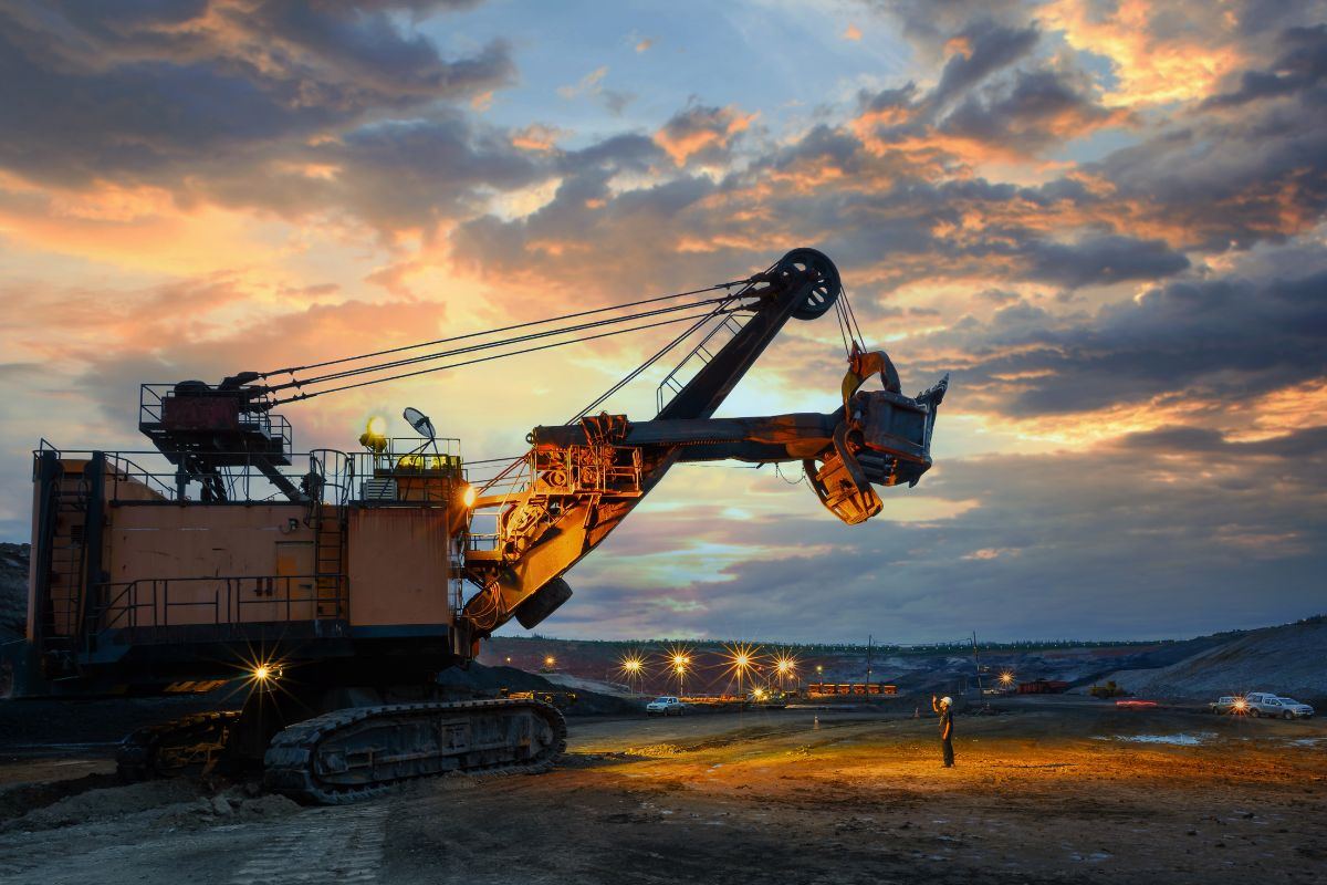 Large electric mining shovel loading at an open pit site at dusk