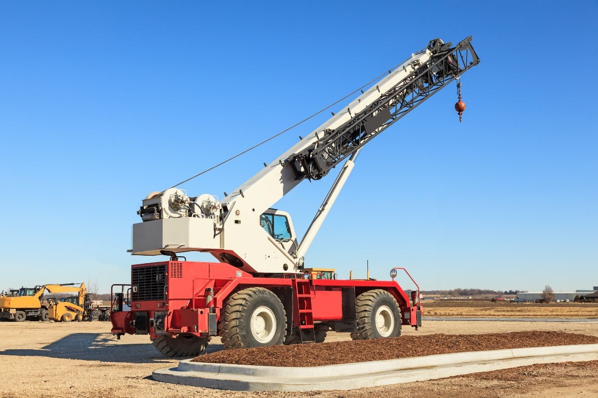 Rough terrain crane with boom extended on a construction site