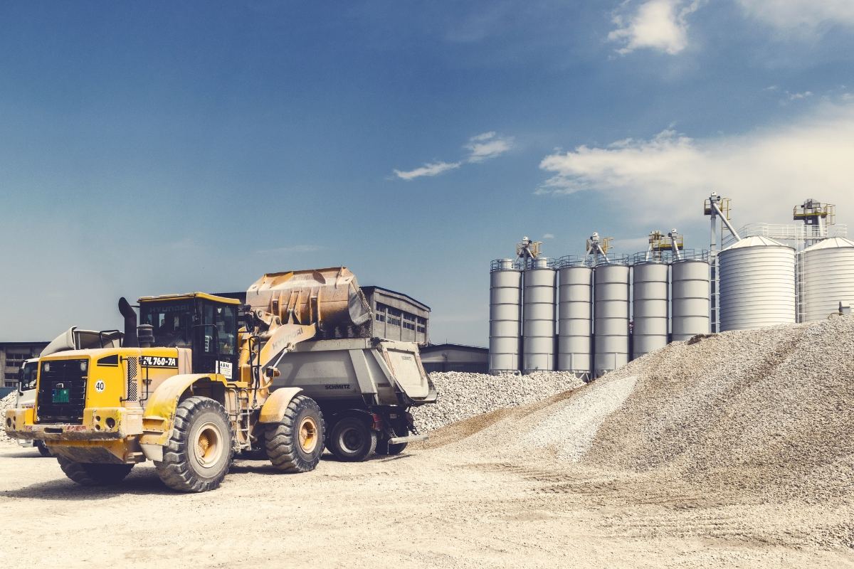Wheel loader moving aggregate at a materials yard with storage silos